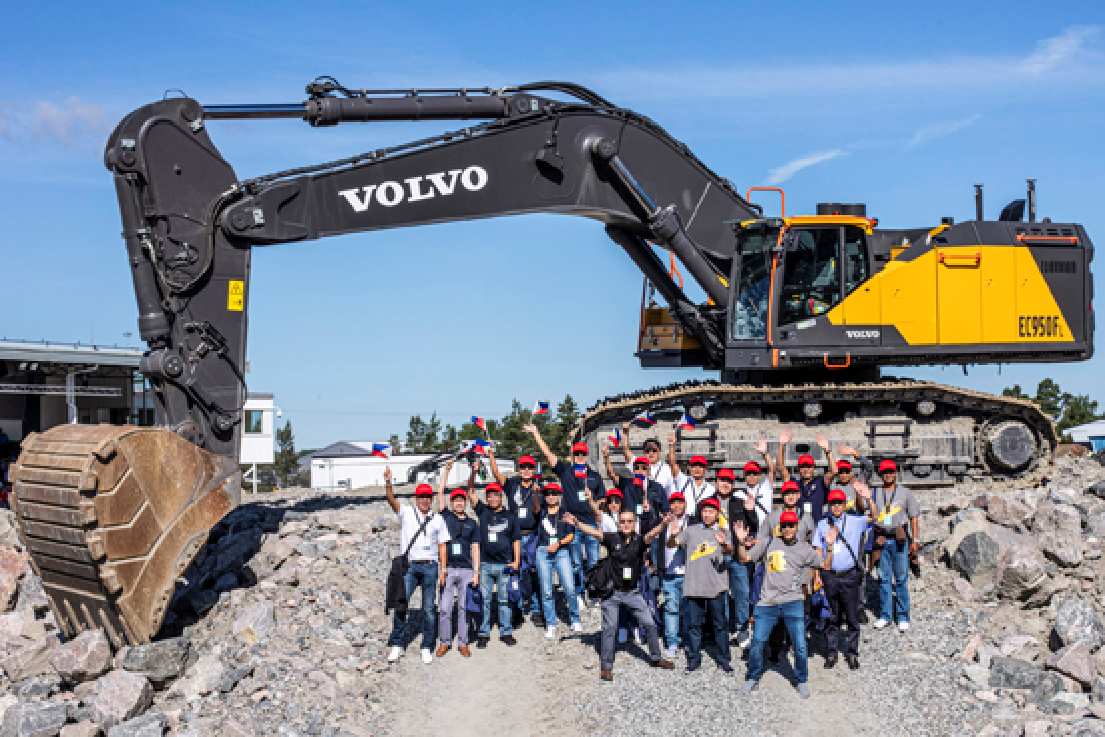 Guests from the Philippines, Thailand, and Japan in front of Volvo’s largest crawler excavator, the EC950F. 