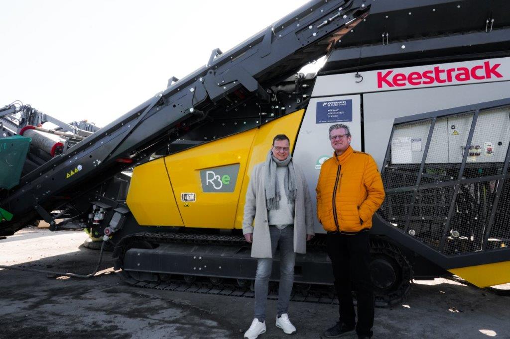 Wolfgang & Hans-Jürgen Büscher in front of the full electric plug-in R3e ZERO impact crusher