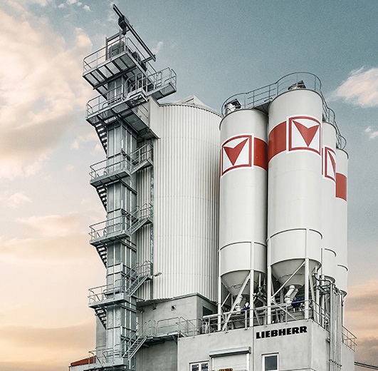 The Betomat 5 mixing plant features two ring-pan mixers, twelve aggregate chambers and six cement silos