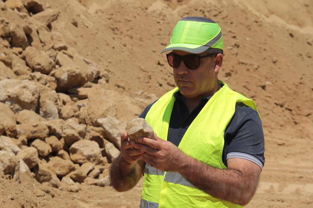 Antonis Latouros inspects a piece of calcareous limestone at one of his group’s quarries