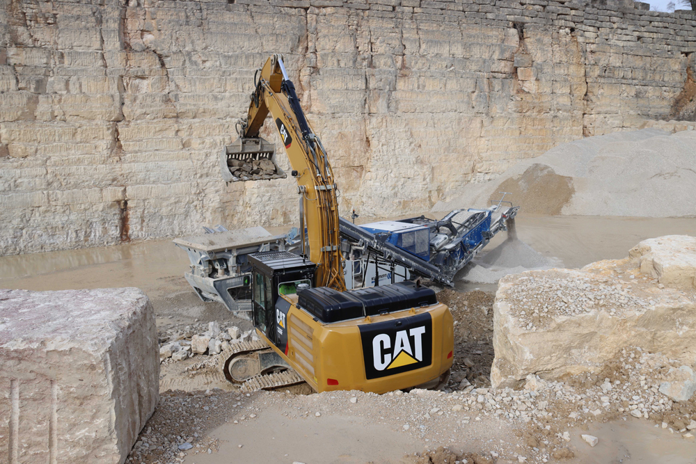 A Cat 336F LN crawler excavator feeding material into a Kleemann crusher