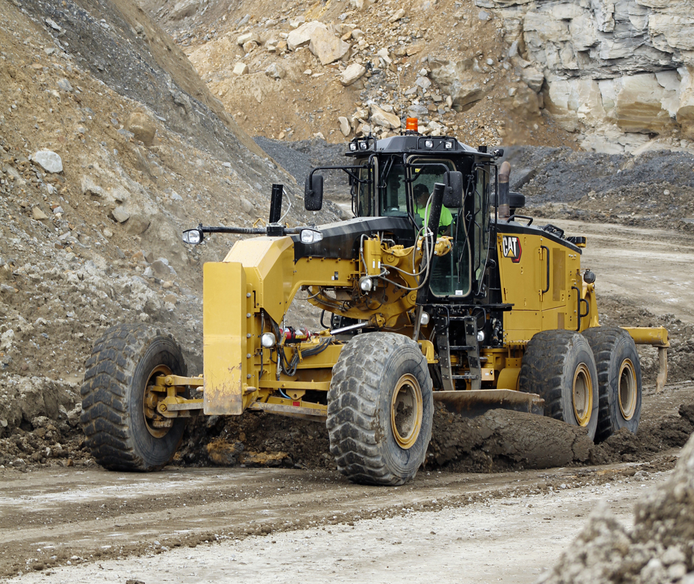 A motor grader driven by a trained operator is crucial in clearing and grading haul roads