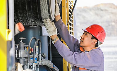An operator changing a filter on a PowerROC D55 DTH surface drill rig at Baota Hill Mine