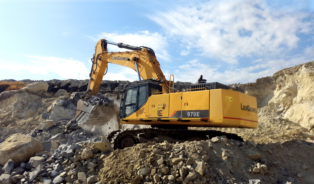 A LiuGong 970E excavator with a bucket full of rock material during a quarrying application