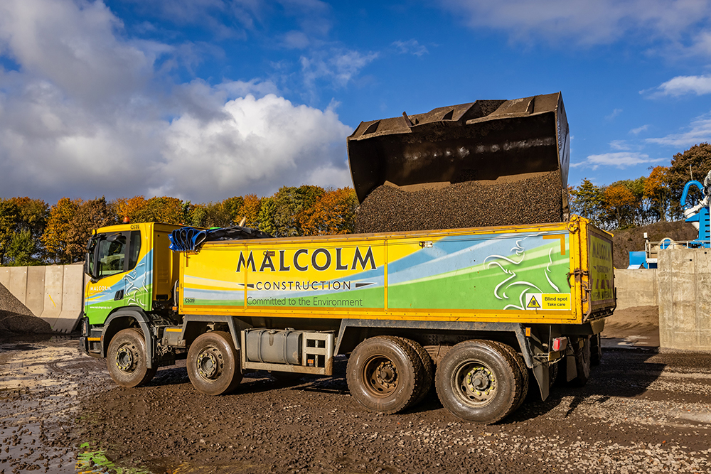 A Malcolm Construction lorry being loaded with processed material