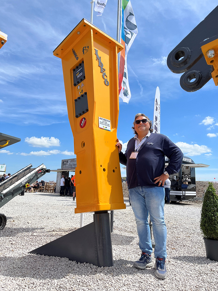 Michele Vitulano in front of one of Indeco’s larger hydraulic hammers on display at Hillhead 2022
