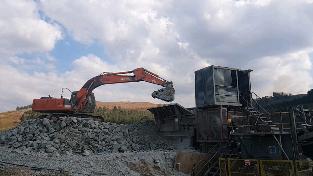 A Hitachi excavator feeding material into the primary jaw crusher at Midmar Crushers’ main plant  