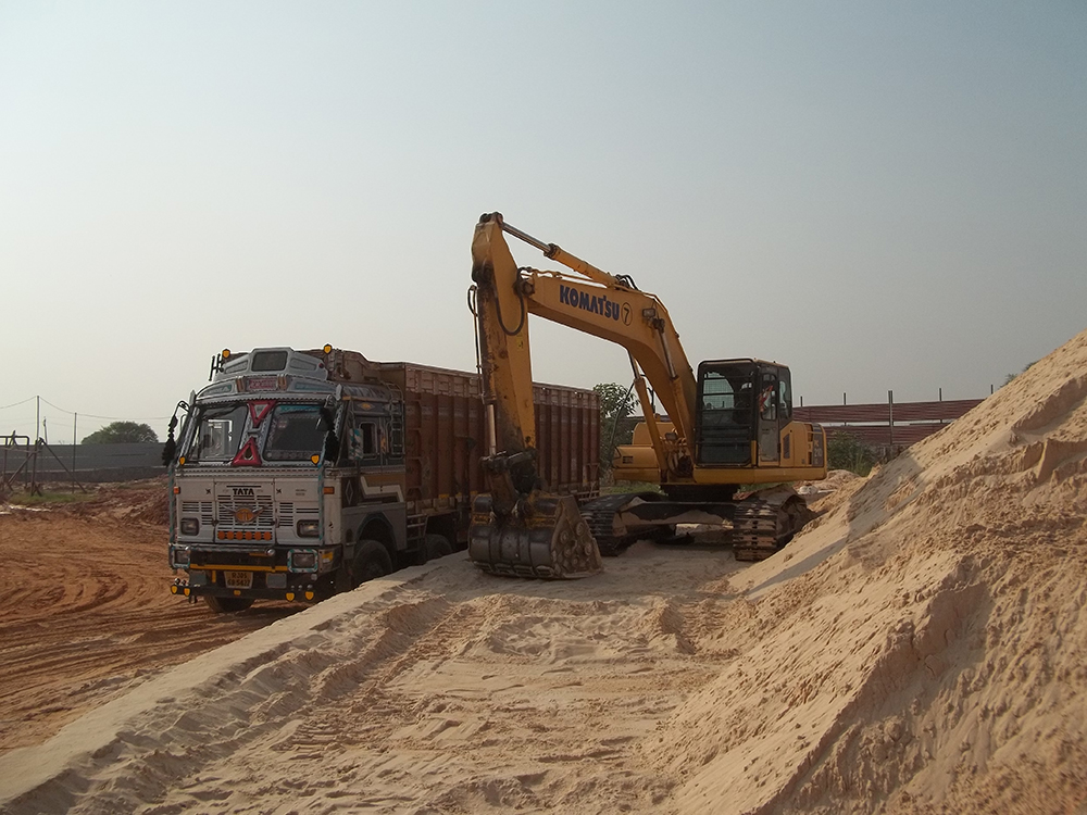 Silica sand being loaded in a high-bodied truck by a Komatsu excavator