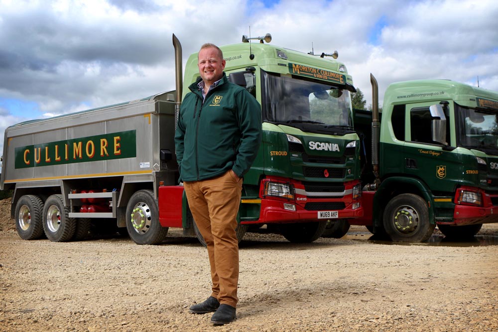 Moreton Cullimore in front of two of The Cullimore Group’s haulage trucks