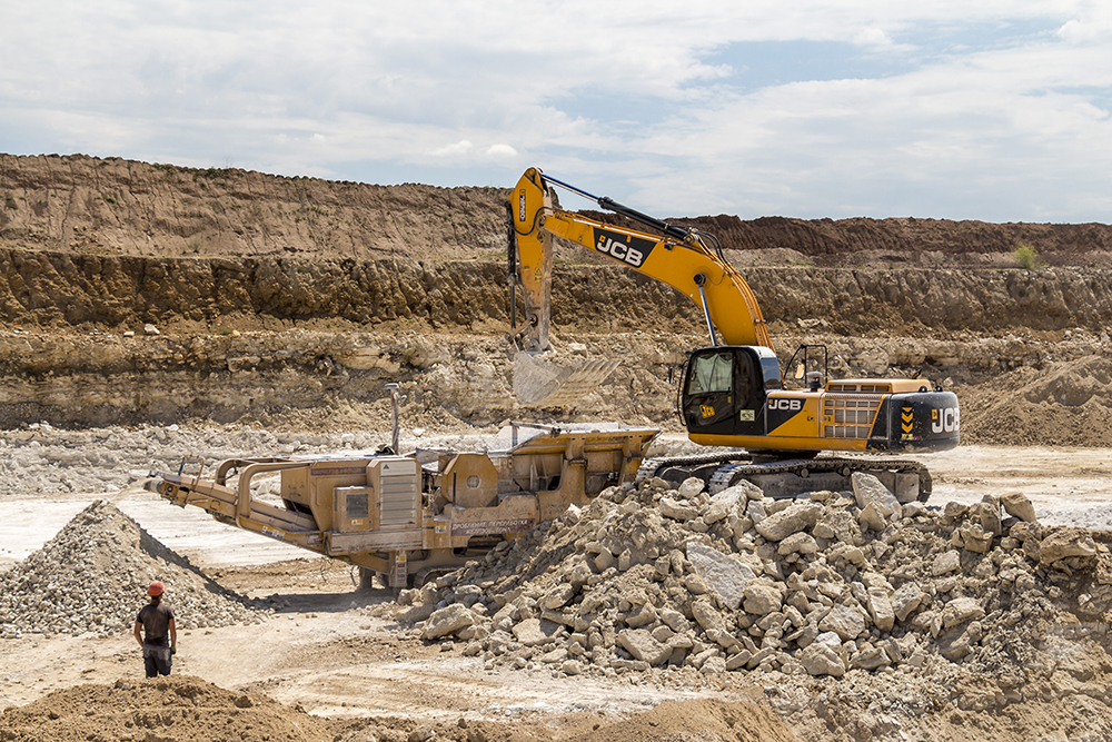 An excavator feeds a crusher at a limestone quarry in Ukraine