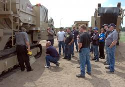 Dealers crowding round a machine during an in-depth training session
